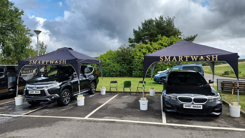 Two cars under SmartWash gazebos at a hand car wash