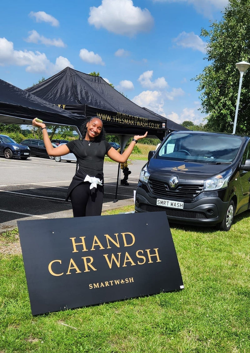 Team member with the SmartWash hand car wash sign and van
