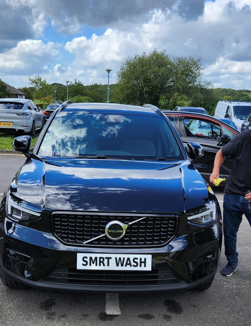 Black Volvo SUV being dried by hand