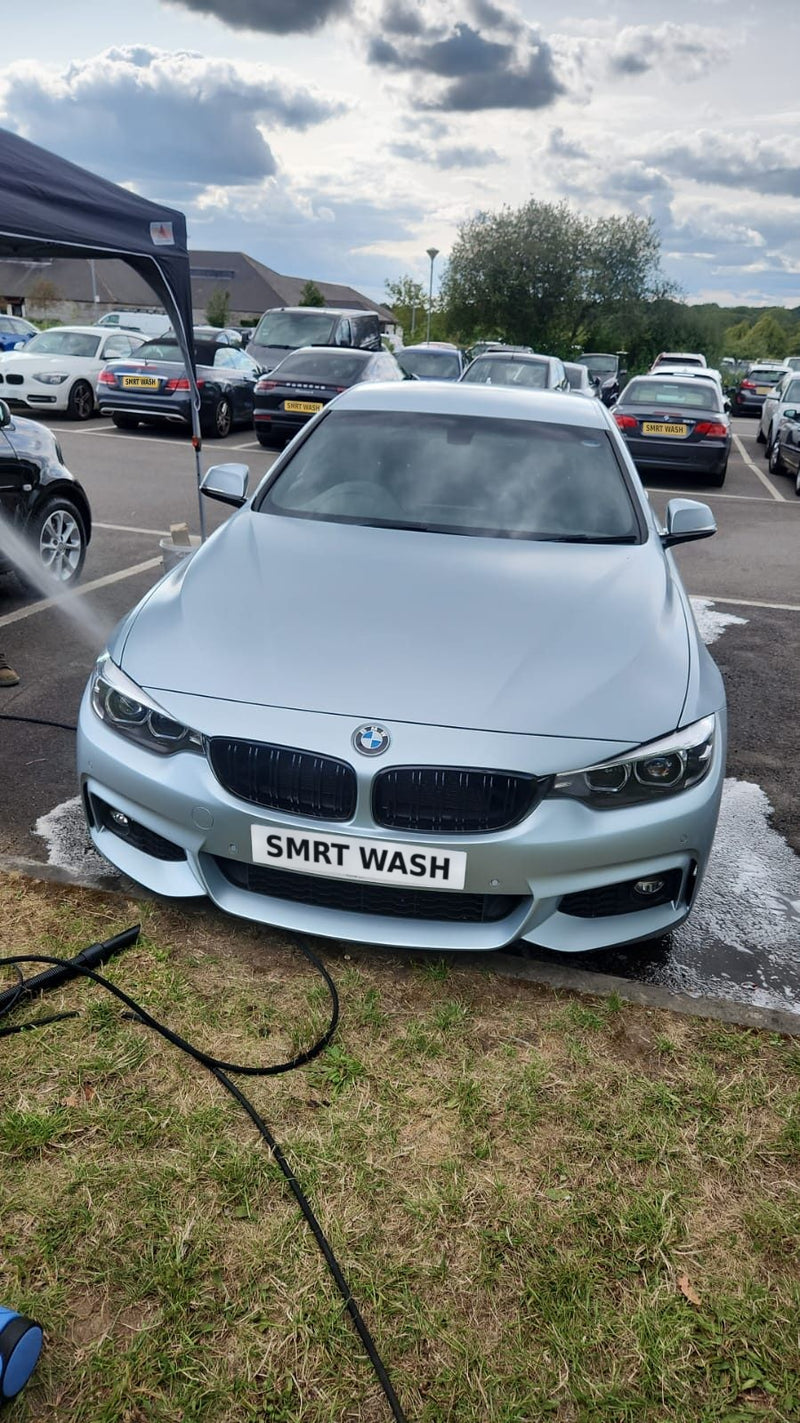 Silver BMW being rinsed at a SmartWash hand car wash